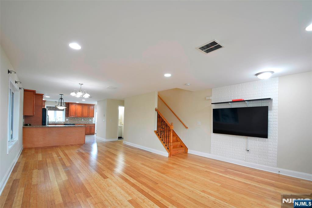12 Pulaski Place, Unit A Hackensack, NJ 07601 - Photo 2 of 29 a view of a livingroom with wooden floor and staircase