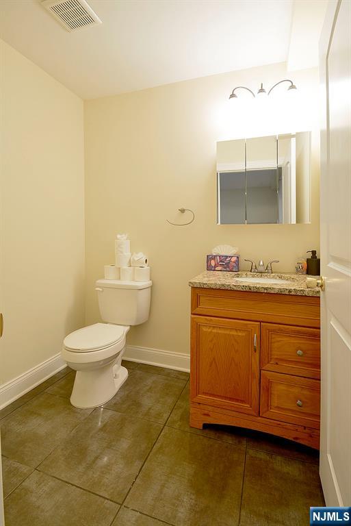 12 Pulaski Place, Unit A Hackensack, NJ 07601 - Photo 23 of 29 a bathroom with a granite countertop toilet sink and mirror