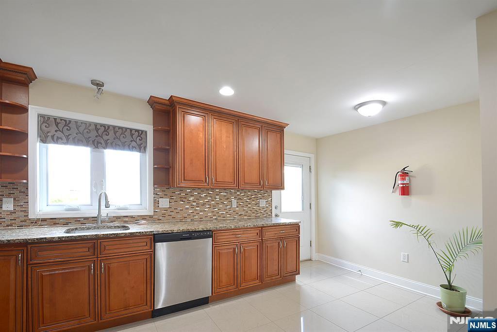 12 Pulaski Place, Unit A Hackensack, NJ 07601 - Photo 8 of 29 a kitchen with granite countertop a sink and a window