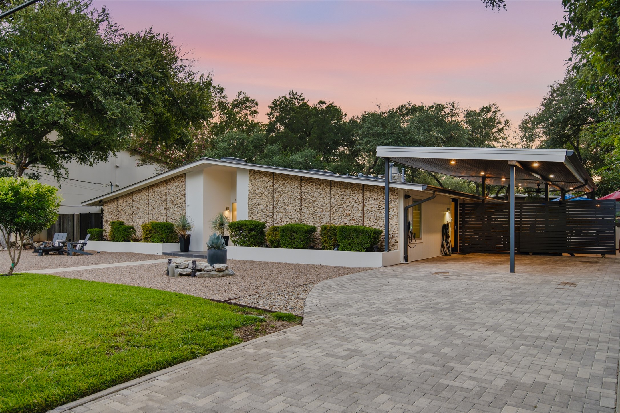 412 Ridgewood Road West Lake Hills, TX 78746 - Photo 4 of 40 A striking modern facade features stone accents, a neatly paved driveway, and new carport