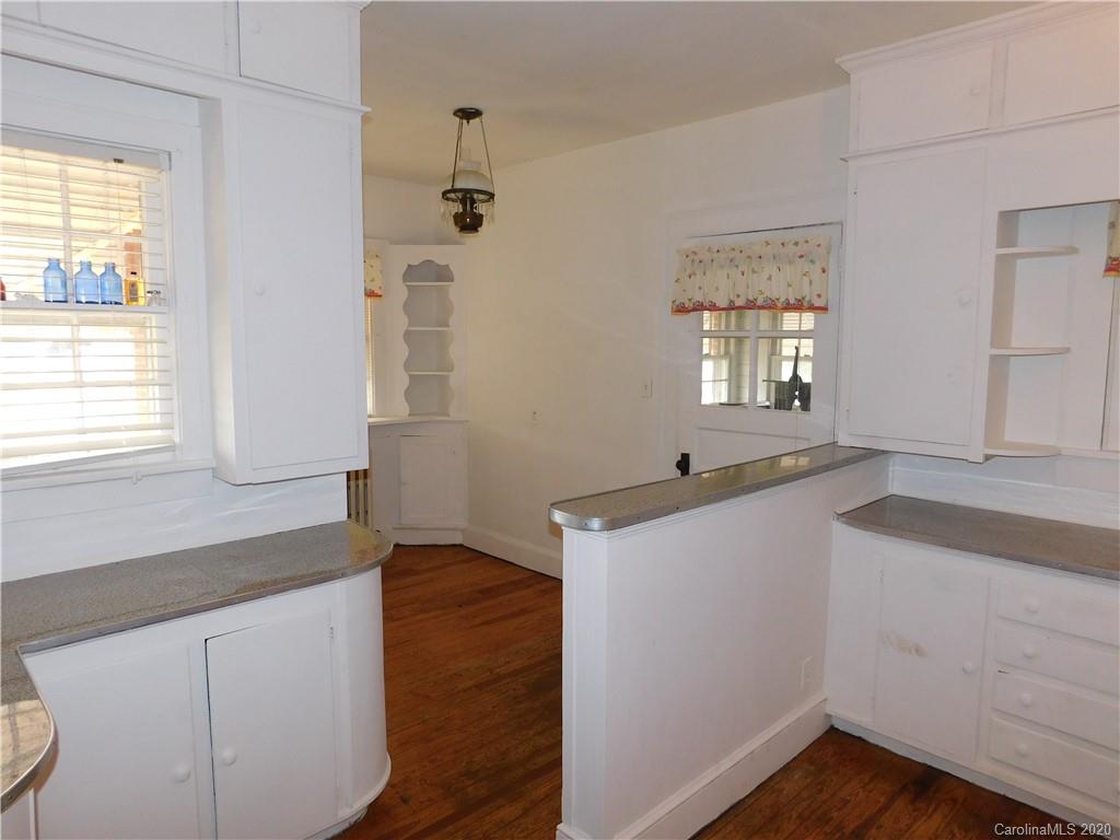 1382 Springdale Road, Unit 7 Lancaster, SC 29720 - Photo 10 of 31 a kitchen with granite countertop white cabinets and wooden floor