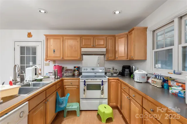 a kitchen with stainless steel appliances granite countertop a sink stove and cabinets