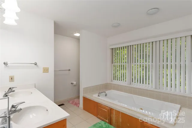a bathroom with a tub sink and mirror