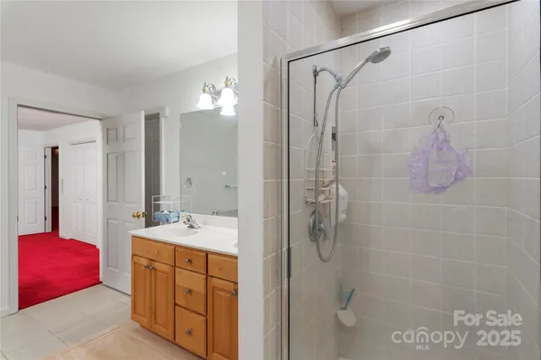 a bathroom with a double vanity sink mirror and shower