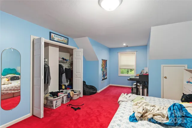 a bedroom with bed and a large mirror