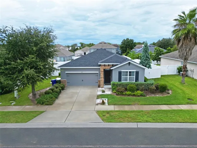a front view of a house with a yard and potted plants