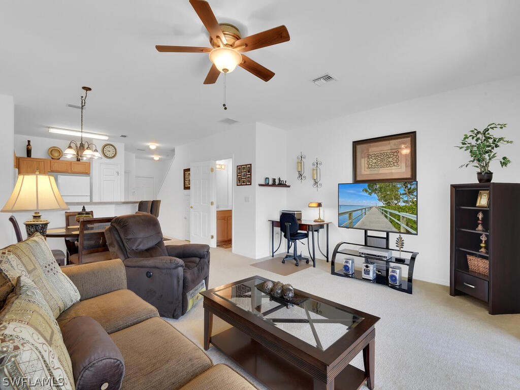 11740 Eros Road Lehigh Acres, FL 33971 - Photo 13 of 30 a living room with furniture a ceiling fan and a flat screen tv