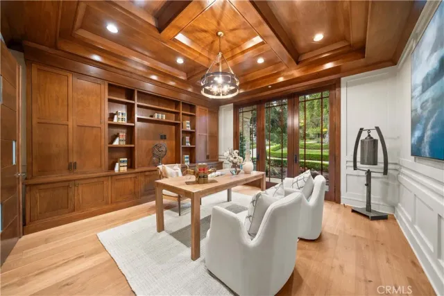 a dining room with wooden floor a chandelier a wooden table and chairs