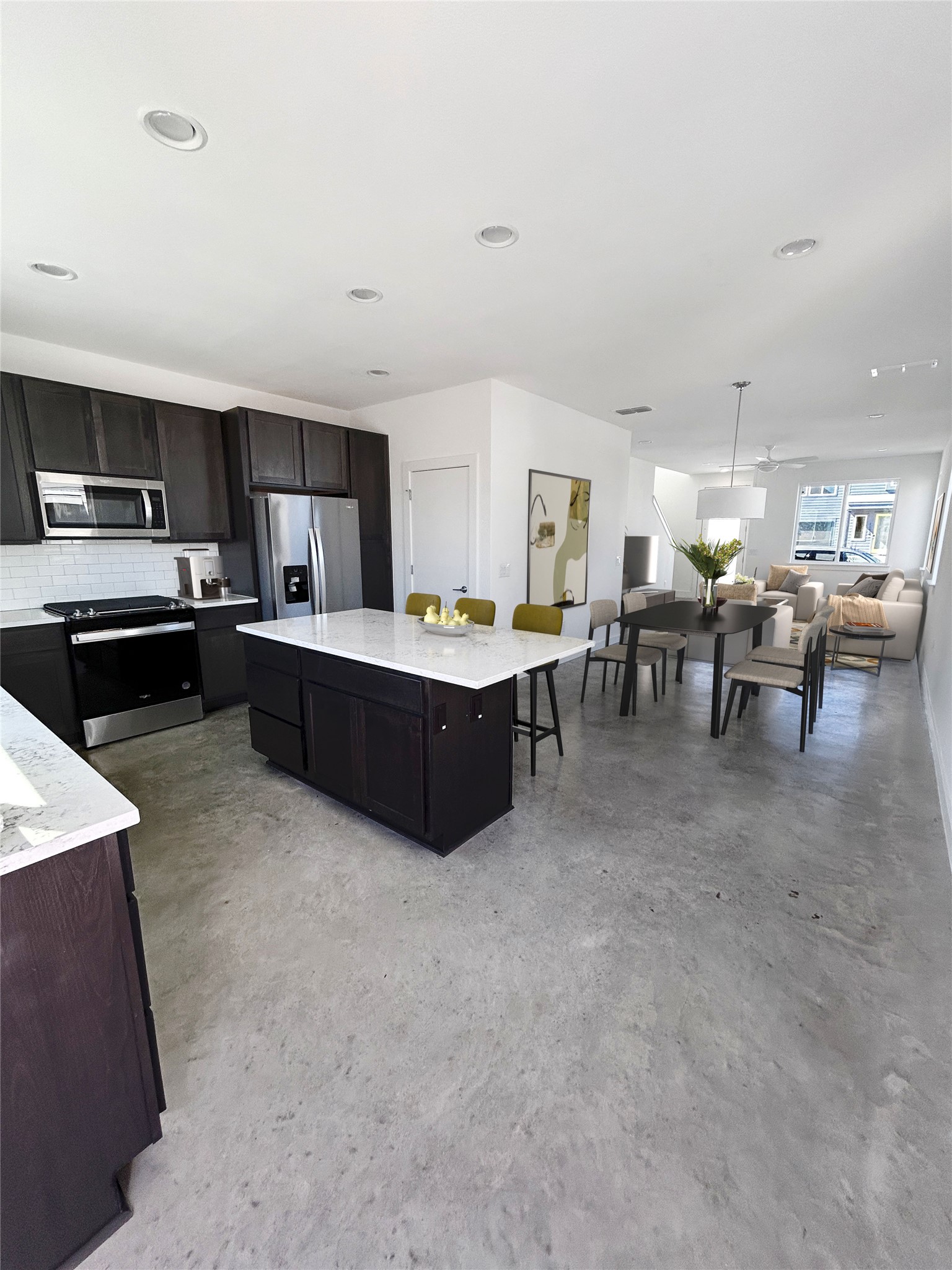 1191 Sarabeth Way Austin, TX 78721 - Photo 4 of 13 Kitchen featuring stainless steel appliances, finished concrete flooring, backsplash, light stone counters, and a kitchen island