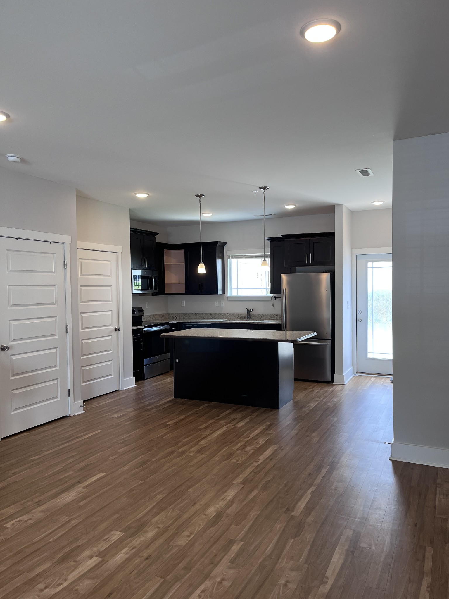 8011 Tuberose Court Spring Hill, TN 37174 - Photo 2 of 20 a kitchen with stainless steel appliances kitchen island wooden cabinets and granite counter tops
