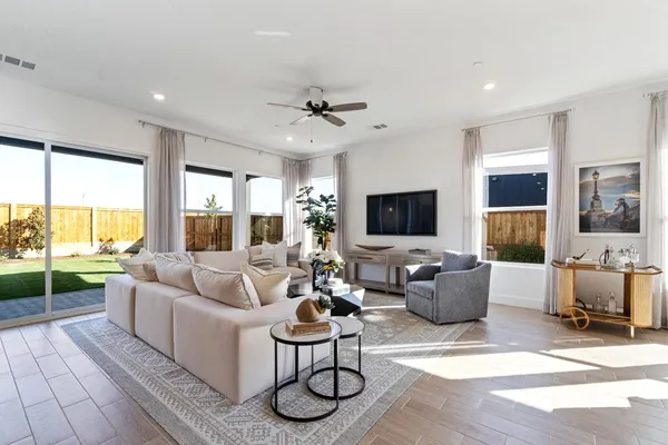 a living room with furniture a flat screen tv and a large window