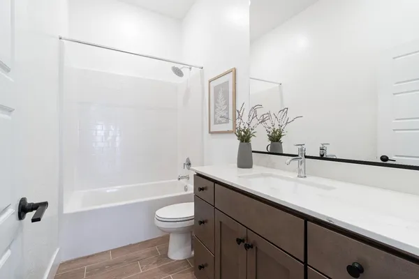 a bathroom with a granite countertop sink a toilet and shower