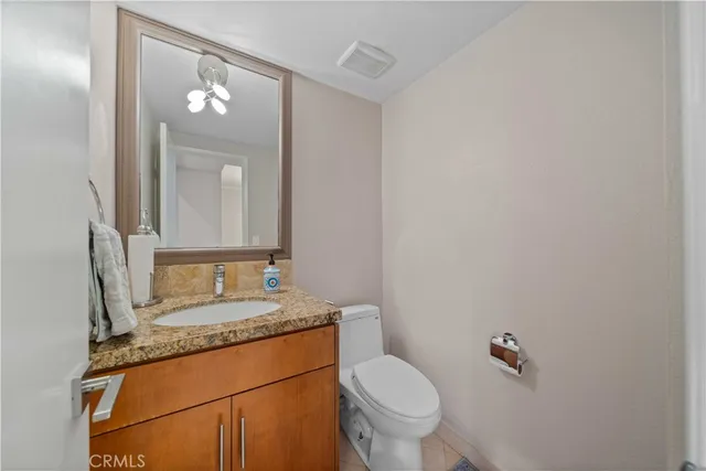 a bathroom with a granite countertop sink mirror and toilet