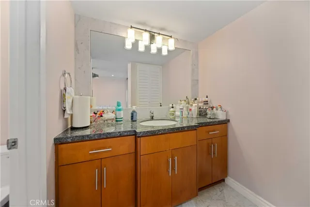 a bathroom with a granite countertop sink and a mirror