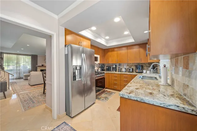 a view of a kitchen with a sink and refrigerator