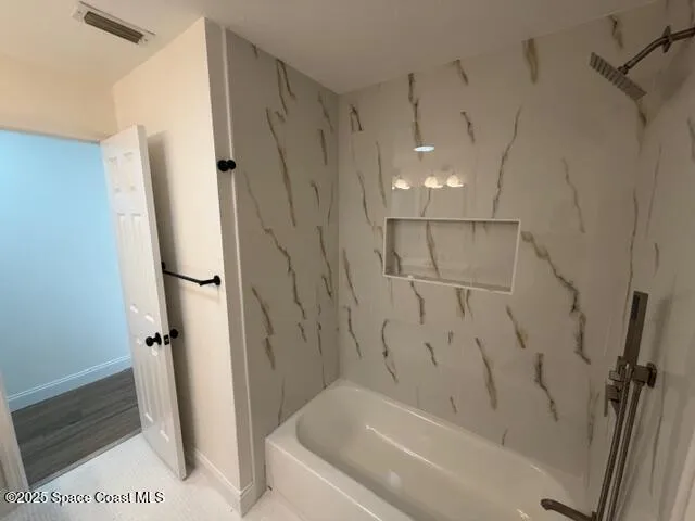 an empty room with wooden floor chandelier fan and windows