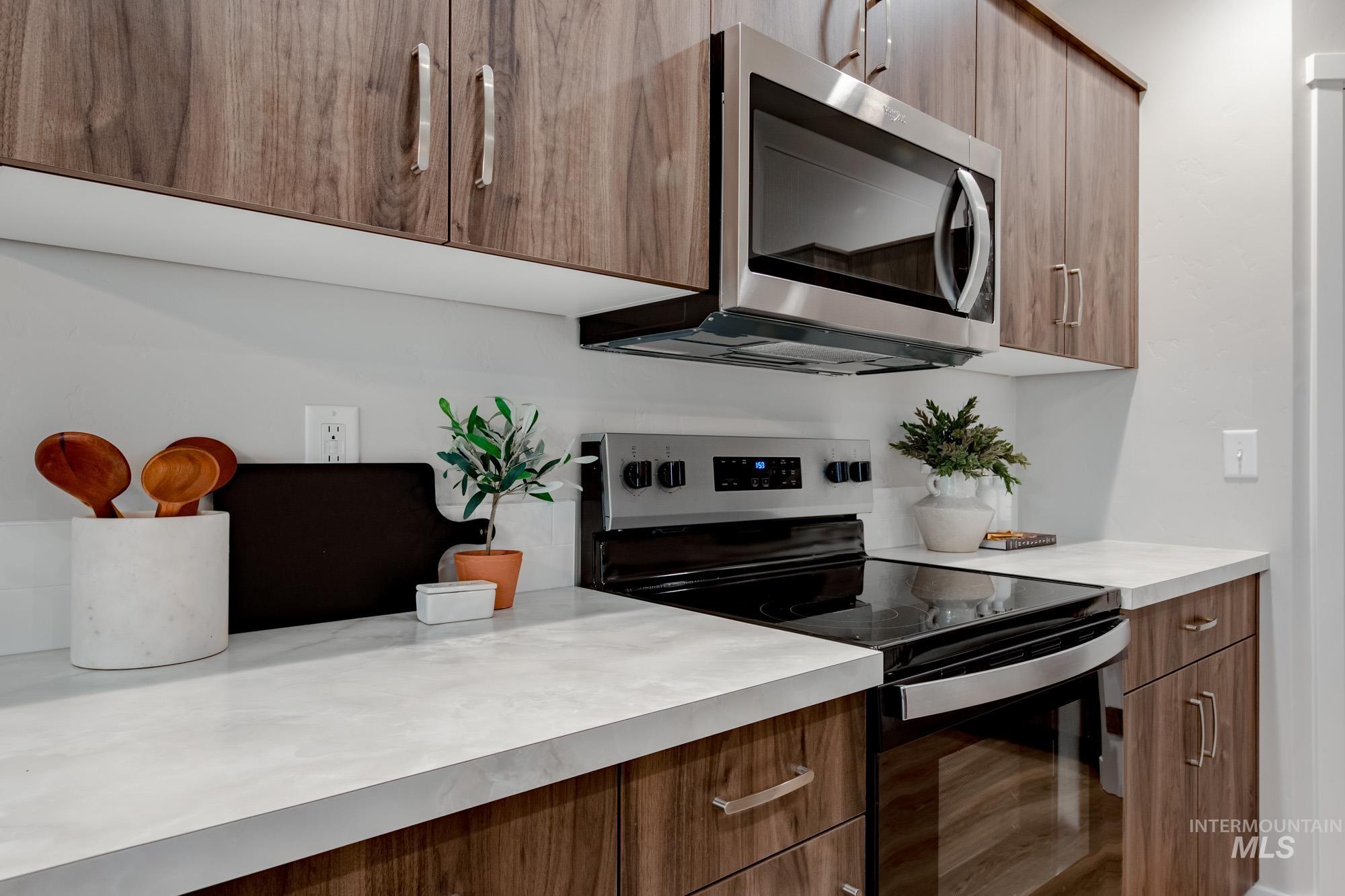 1760 West Unforgettable Street Meridian, ID 83642 - Photo 13 of 26 Kitchen featuring electric range, modern cabinets, stainless steel microwave, and light countertops