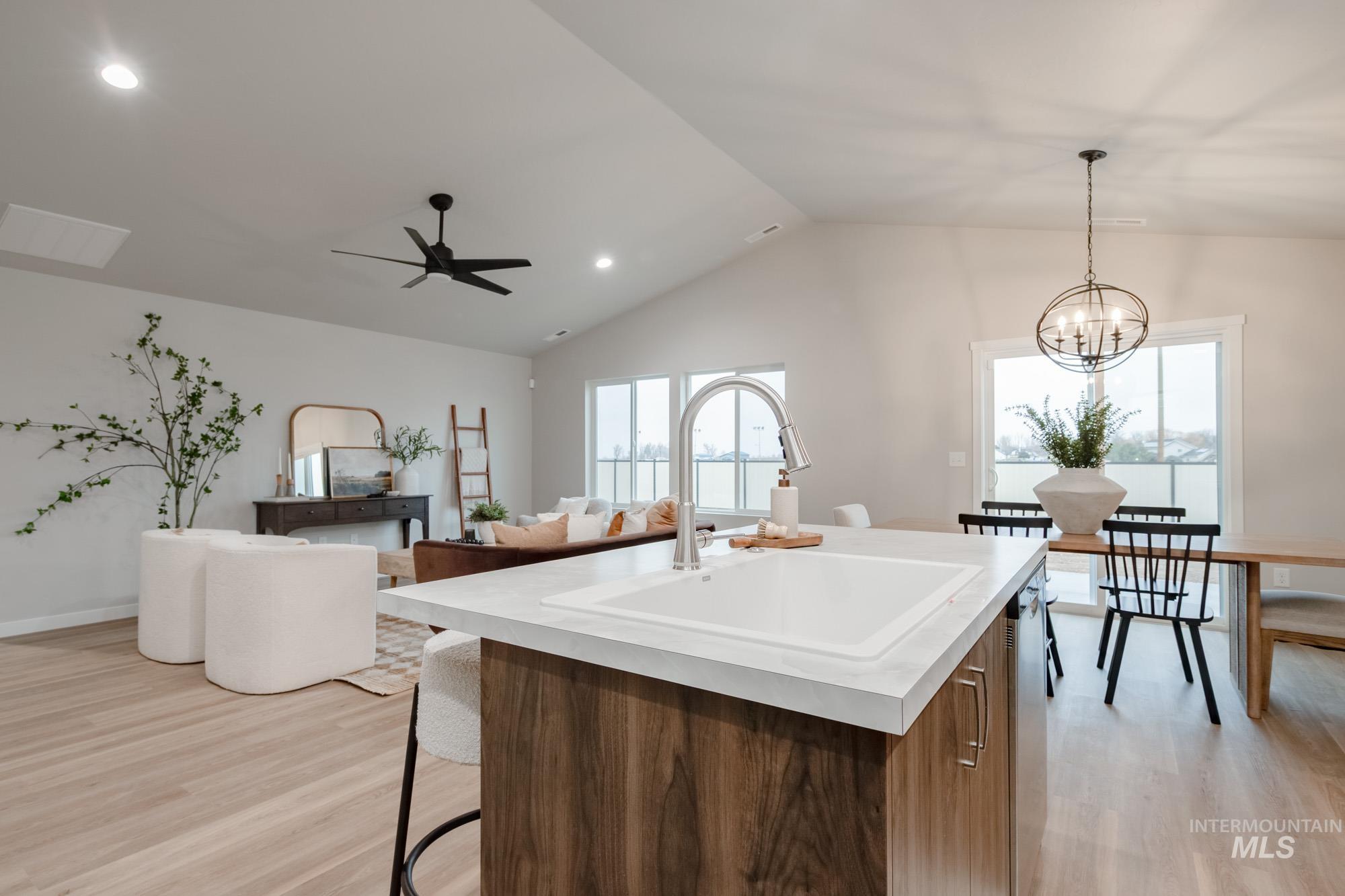 1760 West Unforgettable Street Meridian, ID 83642 - Photo 26 of 26 Kitchen with modern cabinets, a breakfast bar, light wood-style floors, open floor plan, and vaulted ceiling