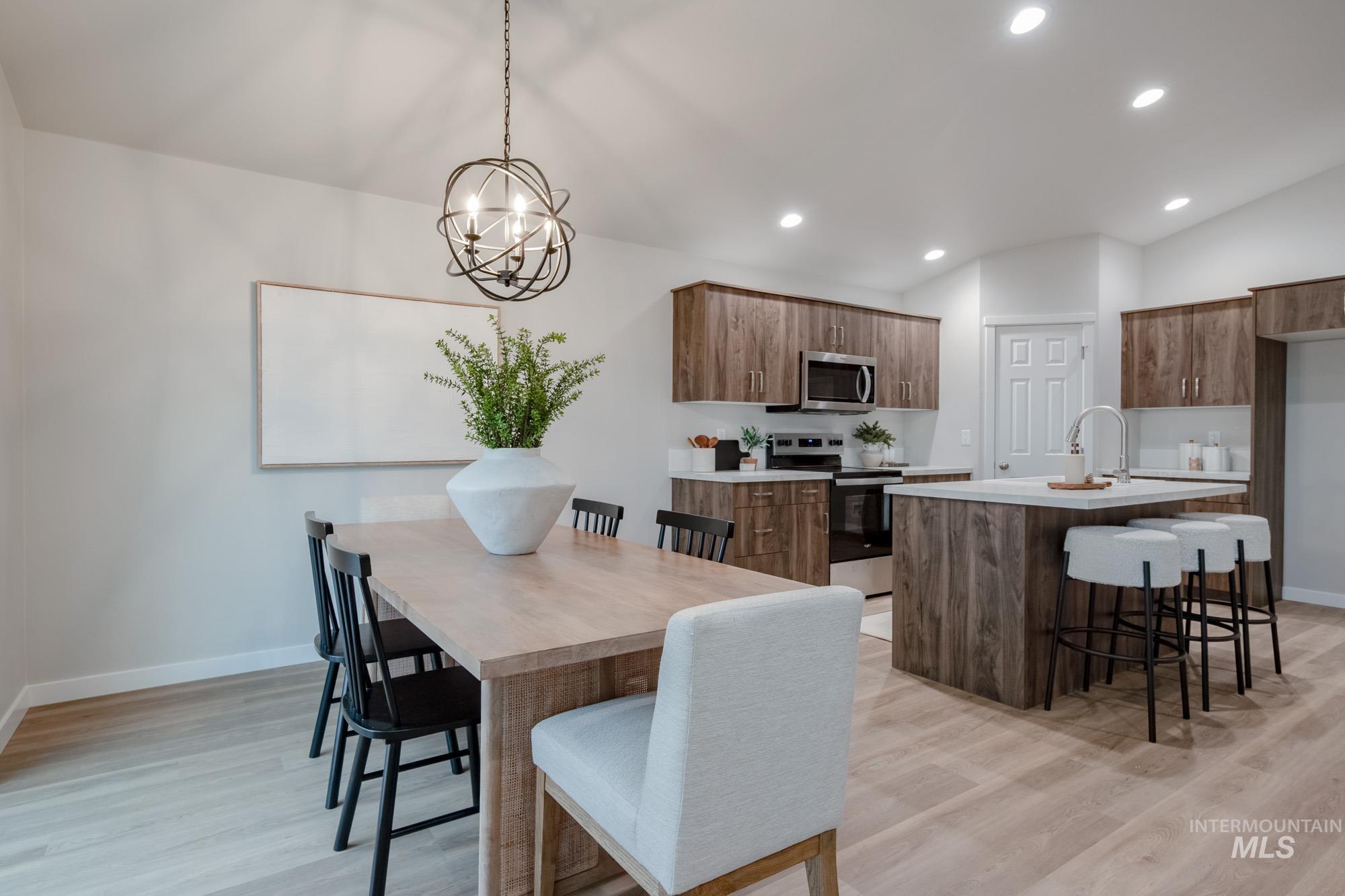 1760 West Unforgettable Street Meridian, ID 83642 - Photo 24 of 26 Dining room featuring lofted ceiling, light wood-style flooring, recessed lighting, and a chandelier