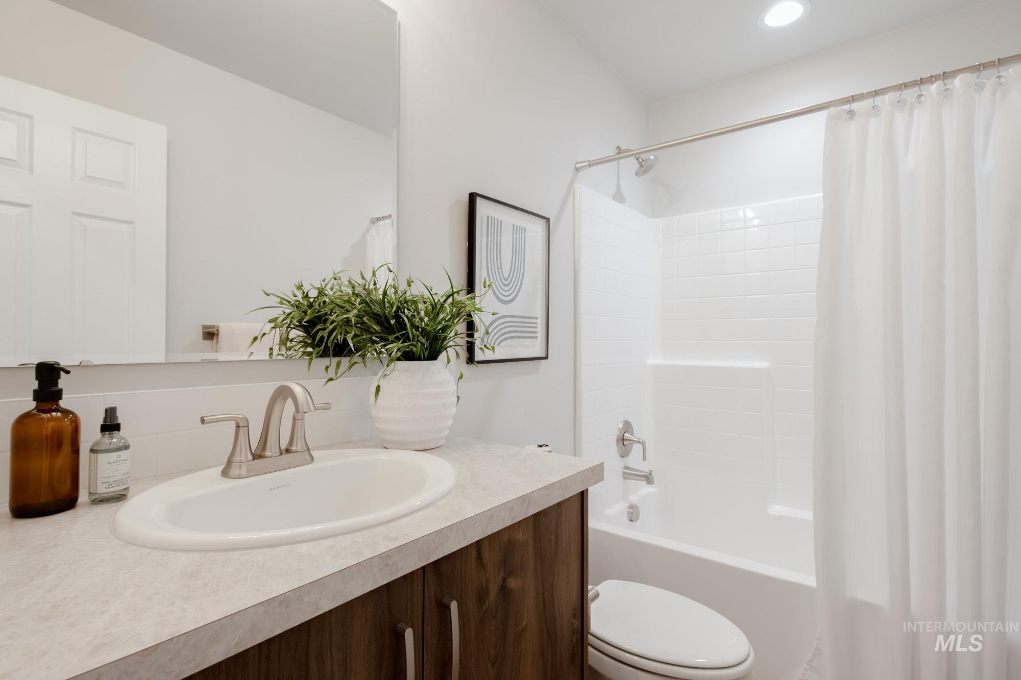 1760 West Unforgettable Street Meridian, ID 83642 - Photo 5 of 26 Bathroom featuring shower / bath combo with shower curtain and vanity