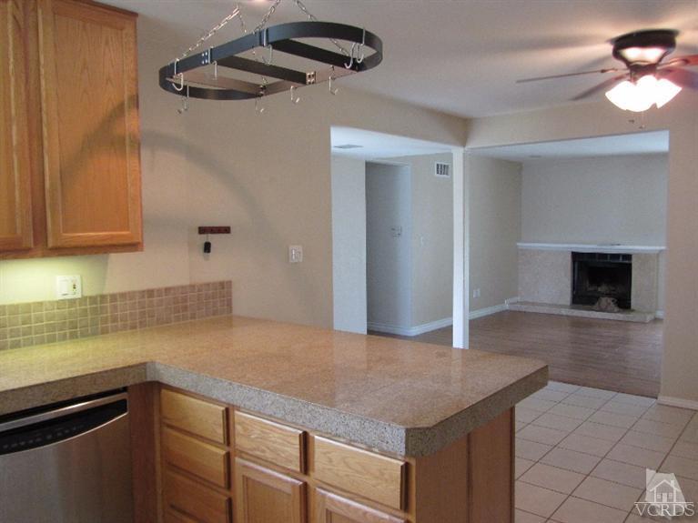 3192 Travis Avenue Simi Valley, CA 93063 - Photo 2 of 36 an empty room with kitchen view and a fireplace