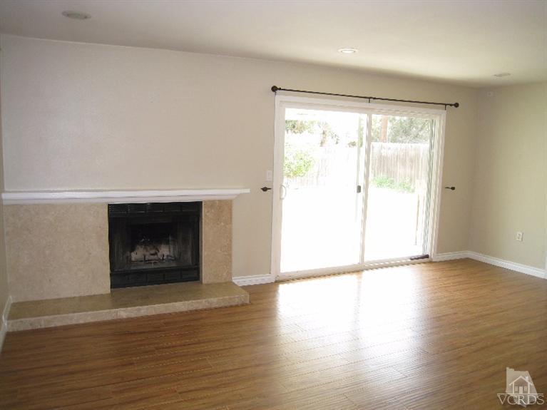 3192 Travis Avenue Simi Valley, CA 93063 - Photo 12 of 36 a view of an empty room with wooden floor fire place and a window