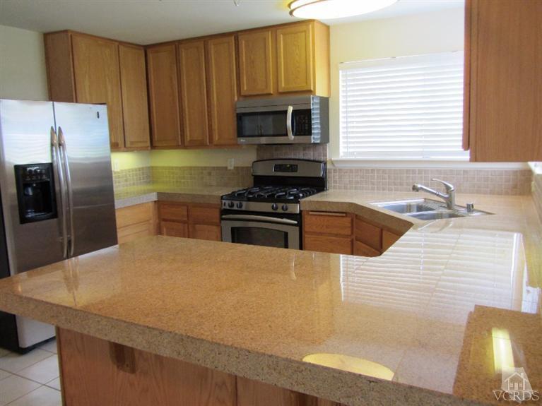 3192 Travis Avenue Simi Valley, CA 93063 - Photo 4 of 36 a kitchen with granite countertop a sink stainless steel appliances and cabinets