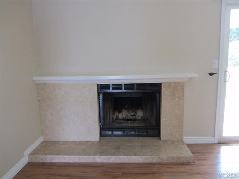 3192 Travis Avenue Simi Valley, CA 93063 - Photo 6 of 36 a view of an empty room with wooden floor fireplace and a window
