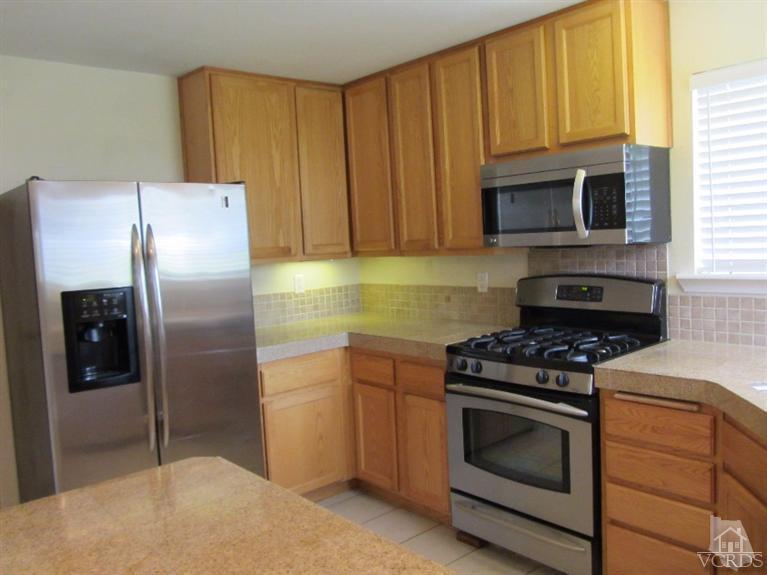 3192 Travis Avenue Simi Valley, CA 93063 - Photo 9 of 36 a kitchen with granite countertop wooden cabinets and stainless steel appliances