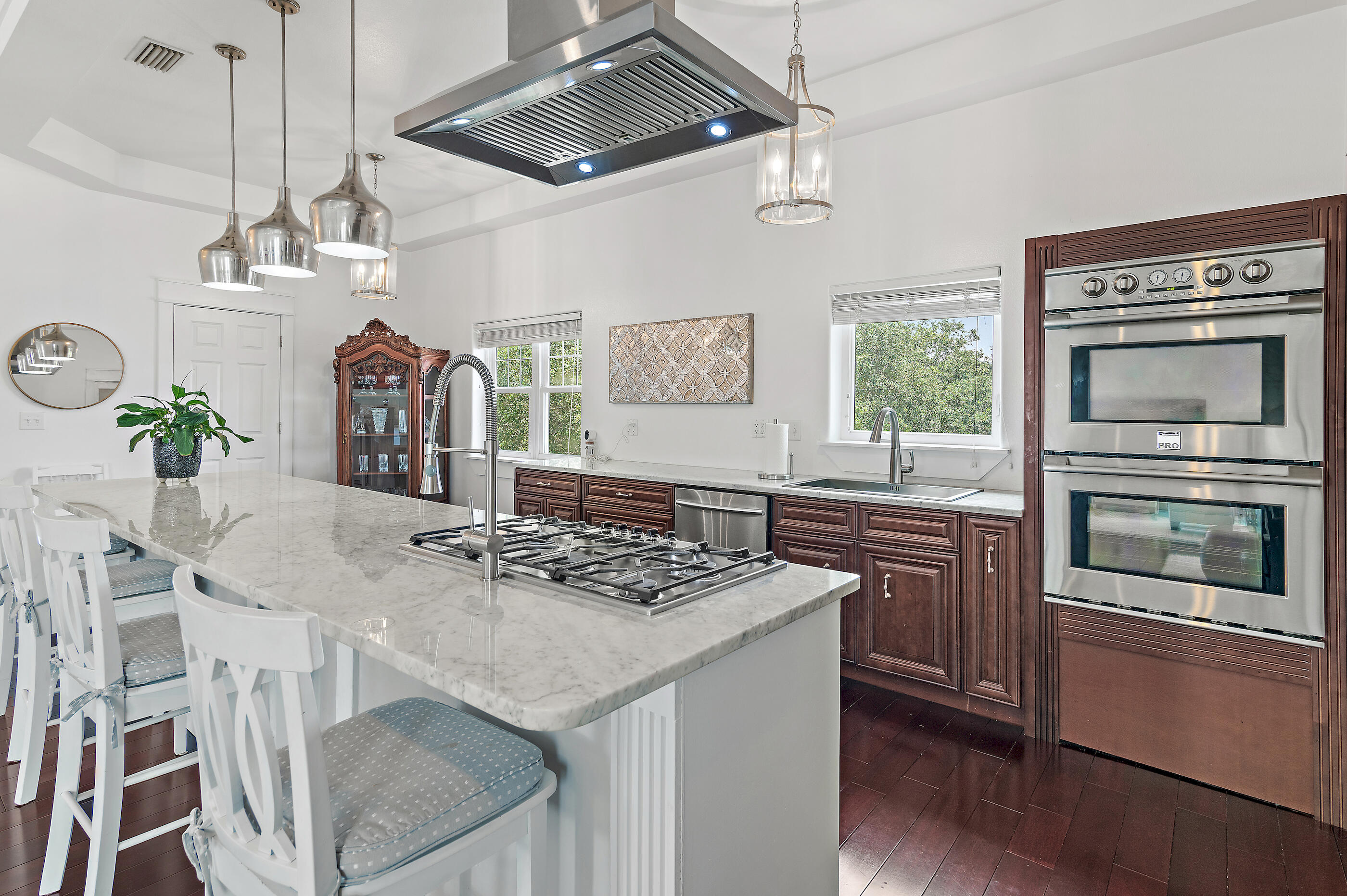 96 Hilltop Drive Santa Rosa Beach, FL 32459 - Photo 14 of 50 a kitchen with stainless steel appliances granite countertop a stove a microwave a dining table and chairs with wooden floor
