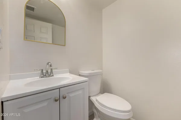 a bathroom with a toilet a sink and mirror