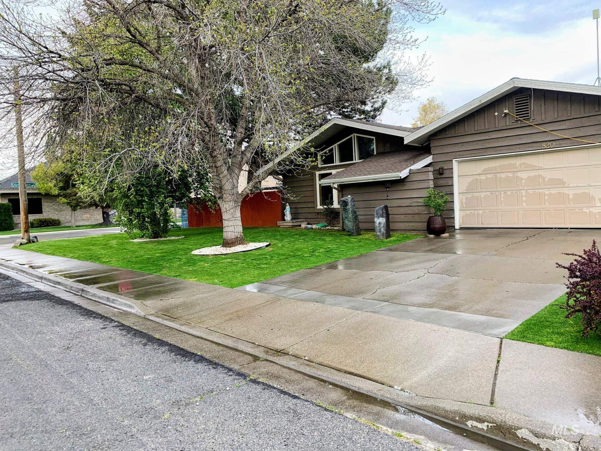 View of front of property with a front lawn, driveway, an attached garage, and board and batten siding