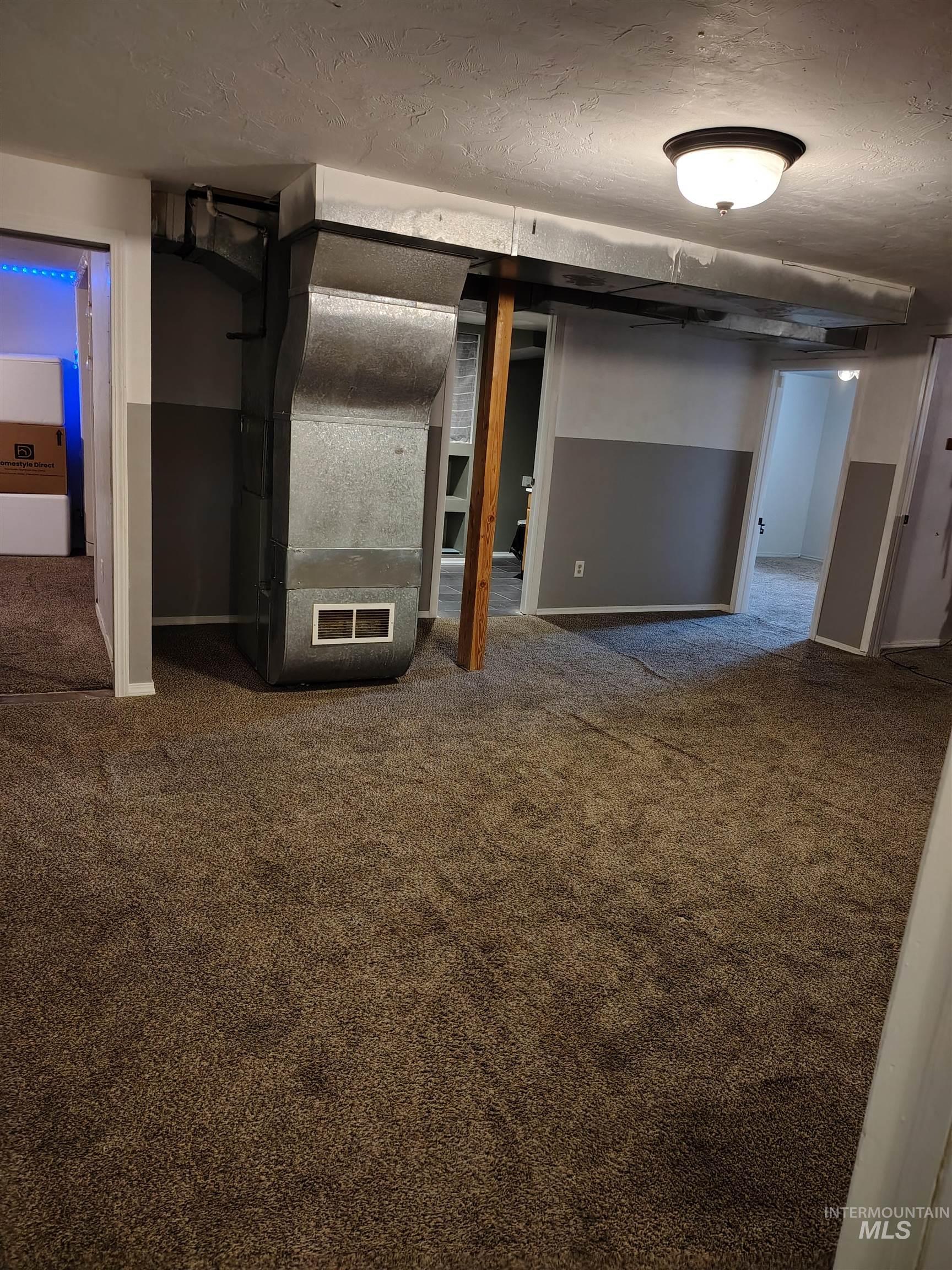 820 Meadows Drive Twin Falls, ID 83301 - Photo 23 of 23 Finished basement featuring carpet flooring, a textured ceiling, and heating unit