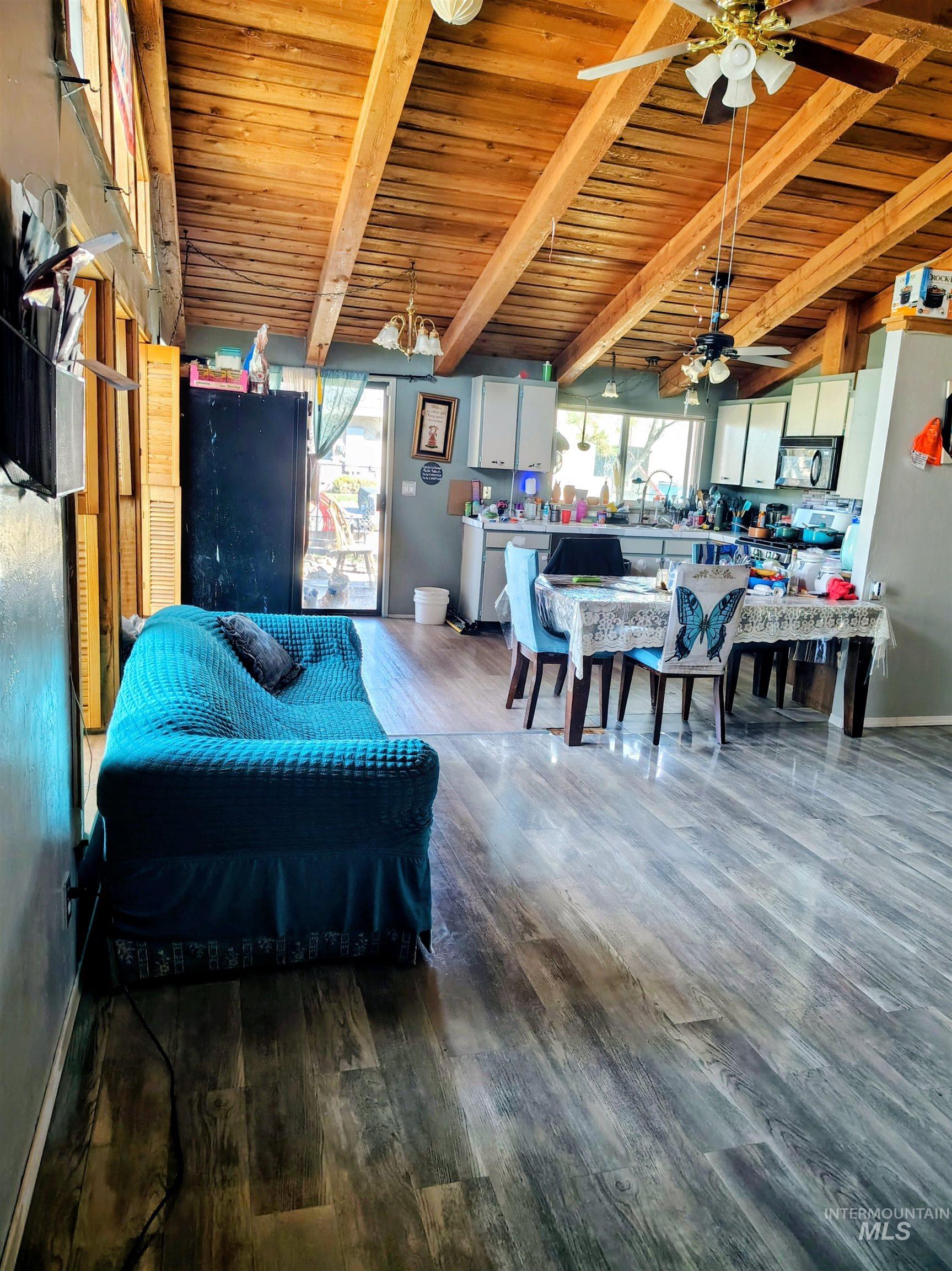 820 Meadows Drive Twin Falls, ID 83301 - Photo 4 of 18 Living area featuring wood ceiling, dark wood-type flooring, vaulted ceiling with beams, and ceiling fan