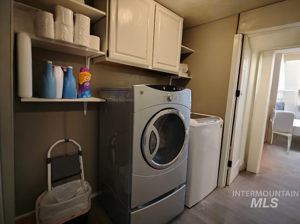820 Meadows Drive Twin Falls, ID 83301 - Photo 5 of 23 Laundry room featuring separate washer and dryer, cabinet space, and wood finished floors