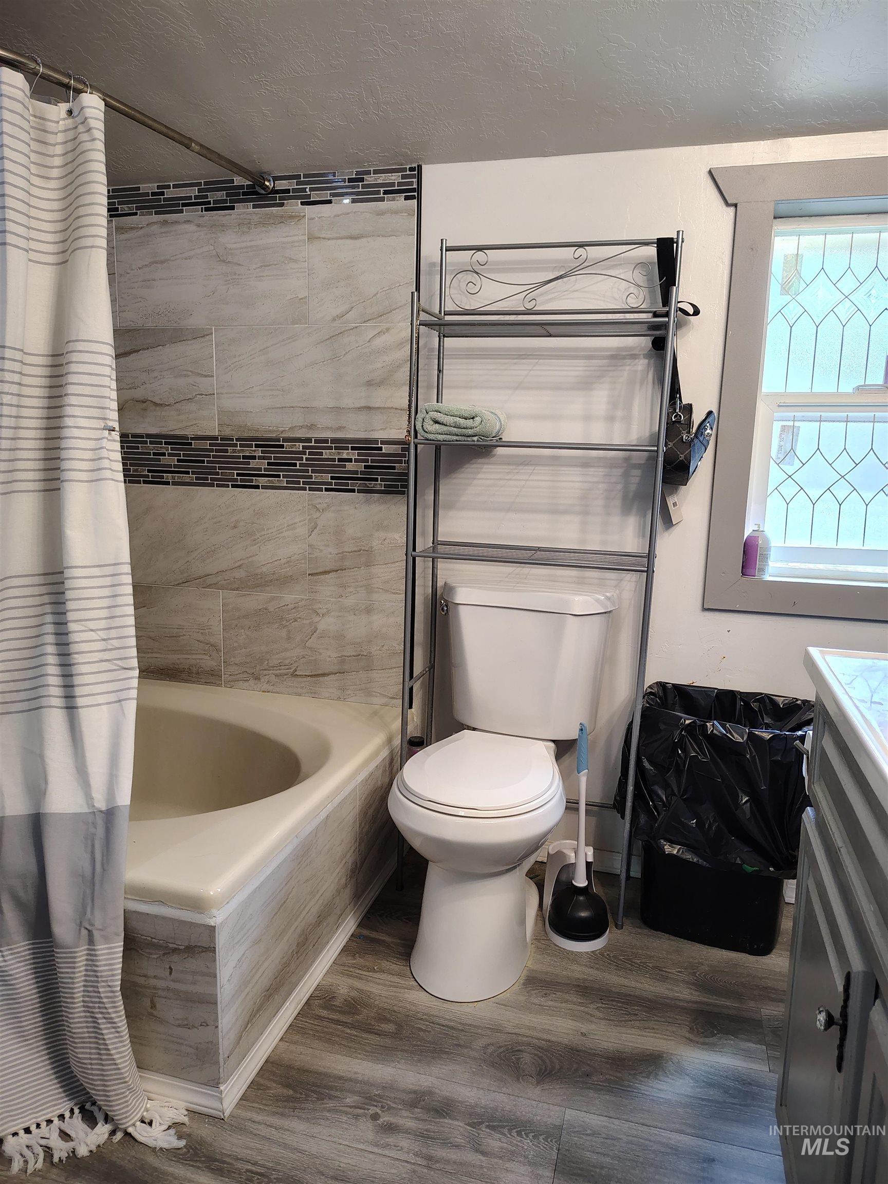 820 Meadows Drive Twin Falls, ID 83301 - Photo 9 of 23 Bathroom featuring vanity, dark wood finished floors, shower / tub combo, and a textured ceiling