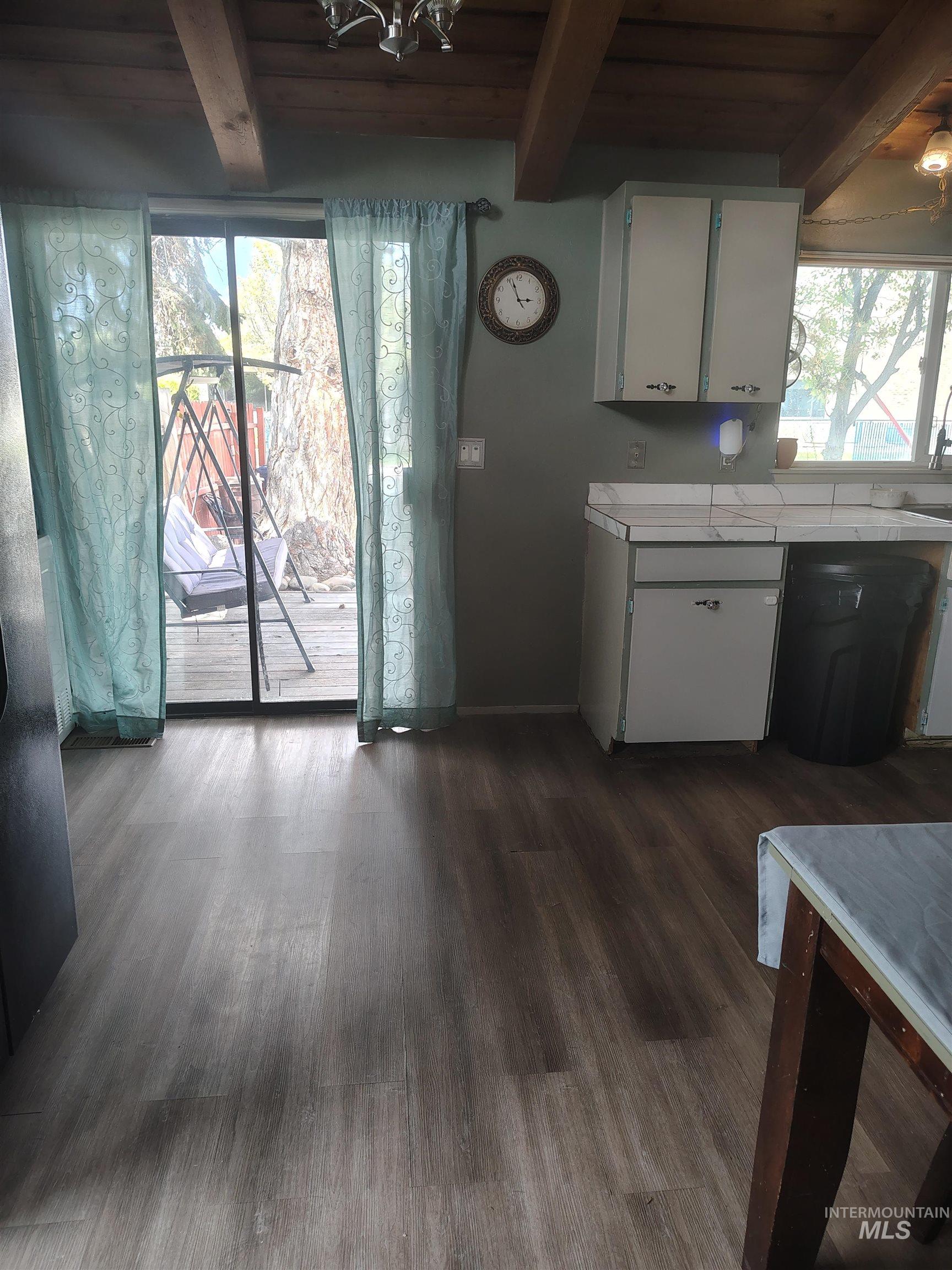 820 Meadows Drive Twin Falls, ID 83301 - Photo 10 of 23 Kitchen with white cabinetry, a wood ceiling with exposed beams, dark wood-type flooring, and tile counters