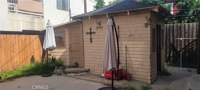 a backyard of a house with potted plants and wooden fence