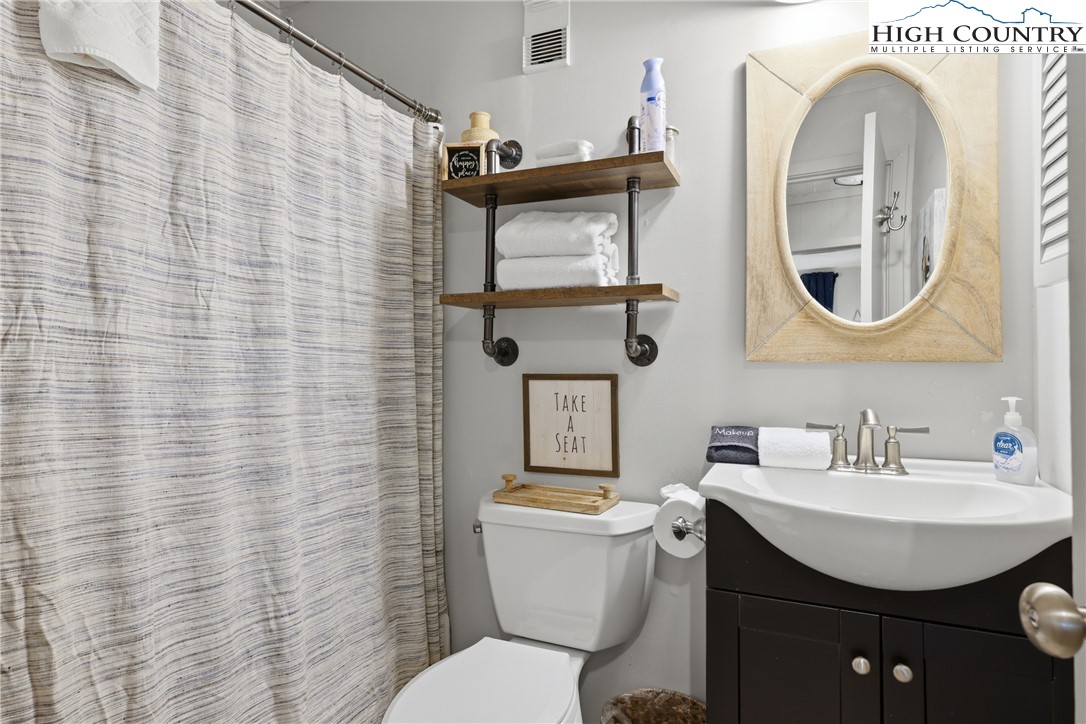 301 Pinnacle Inn Road, Unit 3301 Beech Mountain, NC 28604 - Photo 16 of 34 a bathroom with a toilet a sink and mirror