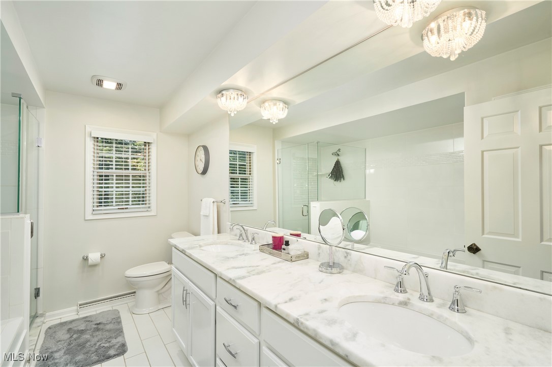 2285 Lancaster Road Akron, OH 44313 - Photo 35 of 48 Full bathroom with a chandelier, double vanity, a shower stall, and light tile patterned flooring