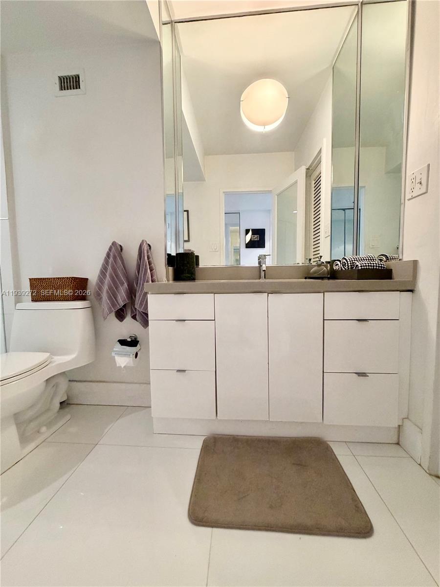 100 Lincoln Road, Unit 1230 Miami Beach, FL 33139 - Photo 15 of 44 a bathroom with a sink and mirror with toilet