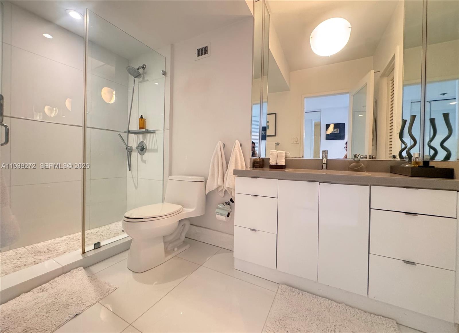 100 Lincoln Road, Unit 1230 Miami Beach, FL 33139 - Photo 4 of 38 a bathroom with a toilet sink and a mirror