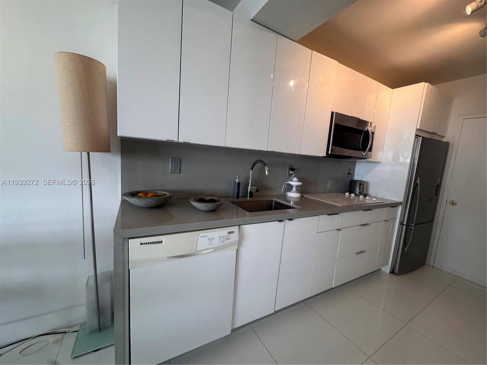 100 Lincoln Road, Unit 1230 Miami Beach, FL 33139 - Photo 5 of 38 a kitchen with stainless steel appliances a sink a stove a microwave a refrigerator and cabinets