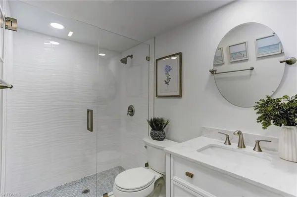 a bathroom with a sink a toilet and shower