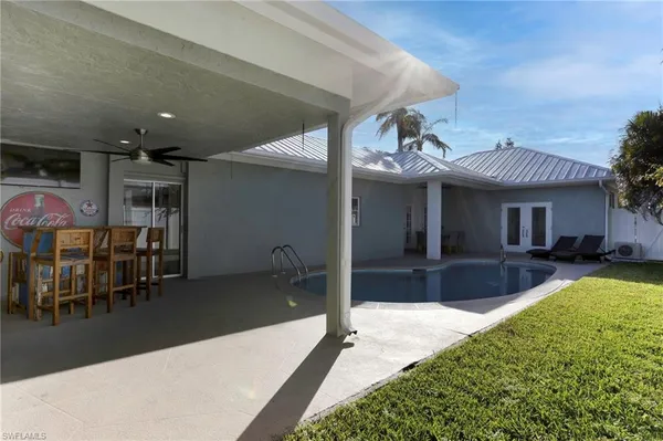 a view of a house with swimming pool and furniture