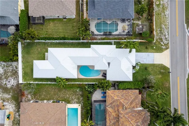 an aerial view of a house with a garden and lake view