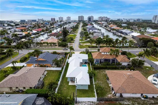 an aerial view of a city with lots of residential buildings ocean and mountain view in back