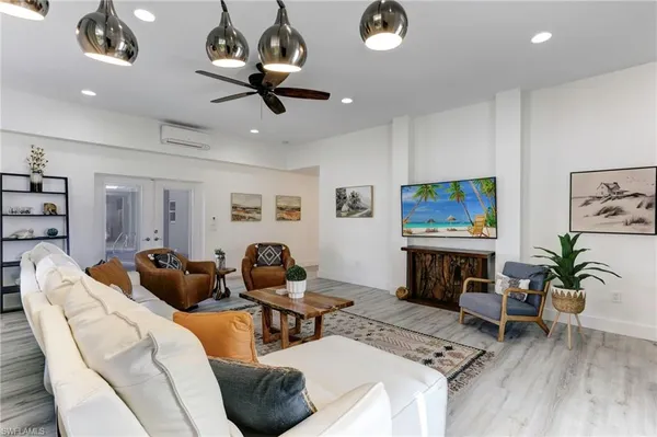 a living room with furniture a flat screen tv and a fireplace