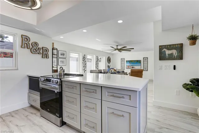 a kitchen with sink cabinets and flat screen tv