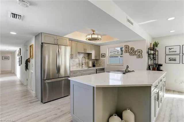 a kitchen with stainless steel appliances granite countertop a sink and a refrigerator